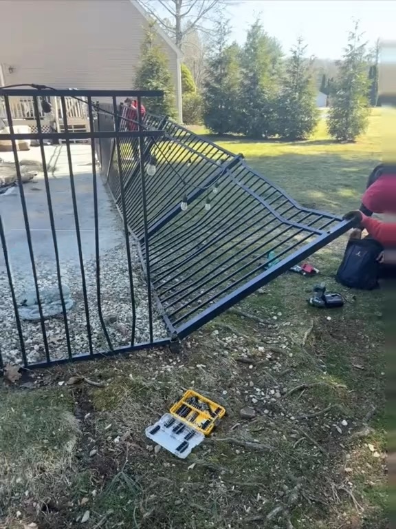 Crew repairing a damaged aluminum fence on site